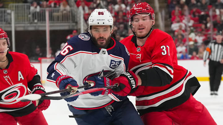 Dec 9, 2025; Raleigh, North Carolina, USA;  Carolina Hurricanes right wing Andrei Svechnikov (37) and Columbus Blue Jackets right wing Kirill Marchenko (86) watch the play during the second period at Lenovo Center. Mandatory Credit: James Guillory-Imagn Images