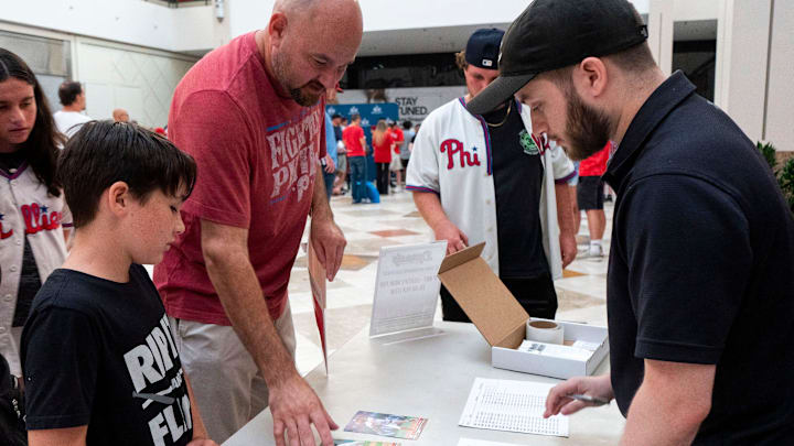 Gino,9, left, and Jason Briamonte, center, get their autographed
Philadelphia Phillies baseball cards from Cristopher Sanchez, Jose Alvarado, and Johan Rojas authenticated by
Vince Diiorio, right, at Dynasty Sports & Framing’s meet and greet event in the Oxford Valley Mall in Langhorne on Thursday, July 25, 2024. Gino,9, left, and Jason Briamonte, center, get their autographed
Philadelphia Phillies baseball cards from Cristopher Sanchez, Jose Alvarado, and Johan Rojas authenticated by
Vince Diiorio, right, at Dynasty Sports & Framing’s meet and greet event in the Oxford Valley Mall in Langhorne on Thursday, July 25, 2024.