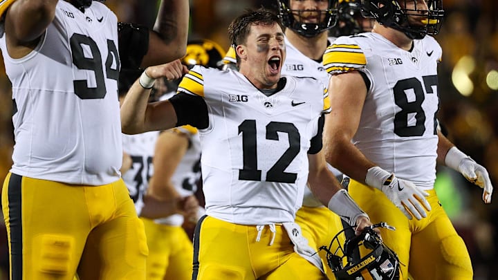 Sep 21, 2024; Minneapolis, Minnesota, USA; Iowa Hawkeyes quarterback Cade McNamara (12) celebrates quarterback Brendan Sullivans (1) touchdown against the Minnesota Golden Gophers during the second half at Huntington Bank Stadium. Mandatory Credit: Matt Krohn-Imagn Images
