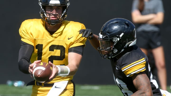 Iowa quarterback Cade McNamara (12) hands the ball off to Kamari Moulton (28) during Kids Day at Kinnick Saturday, Aug. 10, 2024 at Kinnick Stadium in Iowa City, Iowa. Iowa quarterback Cade McNamara (12) hands the ball off to Kamari Moulton (28) during Kids Day at Kinnick Saturday, Aug. 10, 2024 at Kinnick Stadium in Iowa City, Iowa.