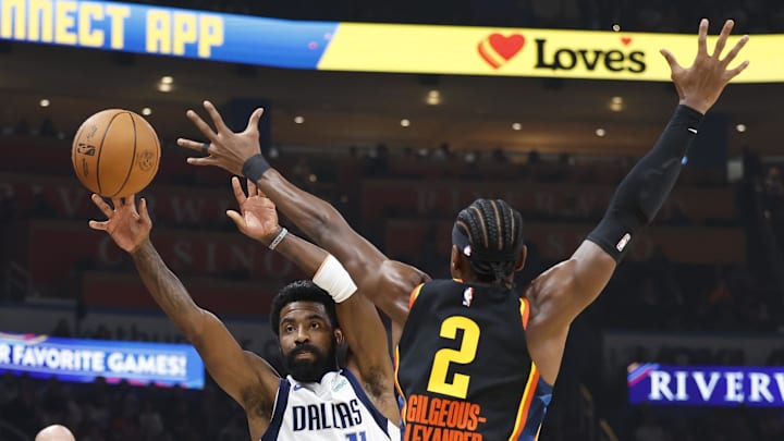 Nov 17, 2024; Oklahoma City, Oklahoma, USA; Dallas Mavericks guard Kyrie Irving (11) passes as Oklahoma City Thunder guard Shai Gilgeous-Alexander (2) defends during the first quarter at Paycom Center