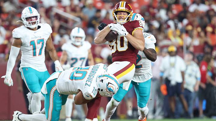 Washington Commanders tight end Colson Yankoff (80) carries the ball as Miami Dolphins linebacker Jacob Rodriguez (10) and Dolphins safety Lonnie Johnson Jr. (32) defend during the first half at Northwest Stadium. 