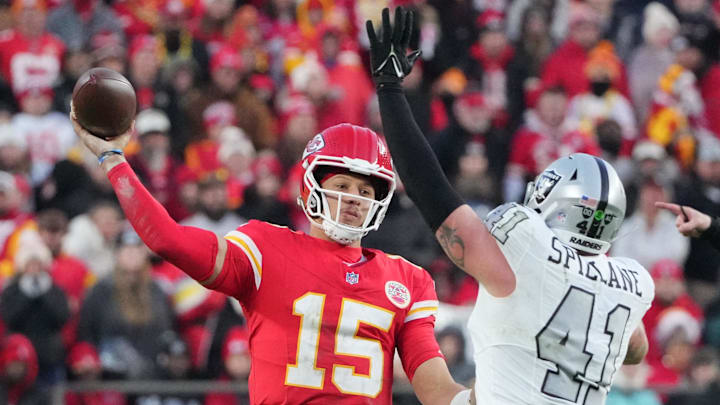 Nov 29, 2024; Kansas City, Missouri, USA; Kansas City Chiefs quarterback Patrick Mahomes (15) throws a pass as Las Vegas Raiders linebacker Robert Spillane (41) defends  during the second half at GEHA Field at Arrowhead Stadium. Mandatory Credit: Denny Medley-Imagn Images