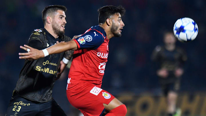 El estadounidense Ventura Alvarado (Bravos) y Alexis Vega (Chivas) compiten por la posesión del esférico.