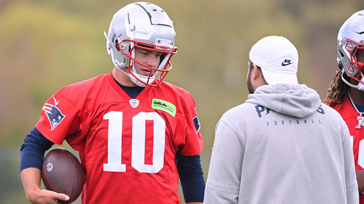 May 11, 2024; Foxborough, MA, USA; New England Patriots quarterback Drake Maye (10) works with a member of the coaching staff at the New England Patriots rookie camp at Gillette Stadium.  Mandatory Credit: Eric Canha-USA TODAY Sports