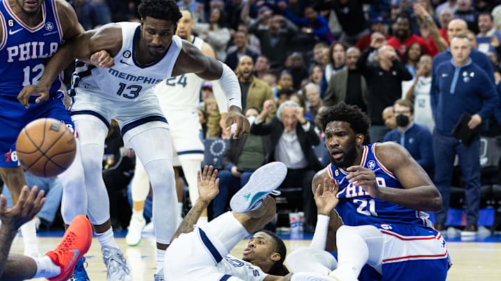  Philadelphia 76ers center Joel Embiid (21) falls to the floor with Memphis Grizzlies guard Ja Morant (12) after blocking his shot attempt during the fourth quarter at Wells Fargo Center. Mandatory Credit: Bill Streicher-Imagn Images