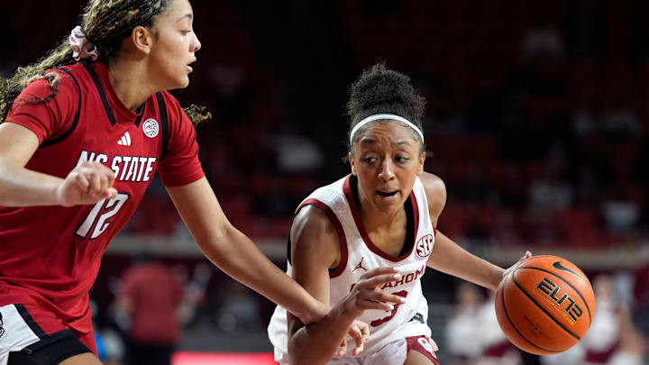 Oklahoma Sooners guard Zya Vann (3) dribbles beside NC State Wolfpack forward Khamil Pierre (12) during a women's college basketball game between Oklahoma and North Carolina State at Lloyd Noble Center in Norman, Okla., Wednesday, Dec. 3, 2025.