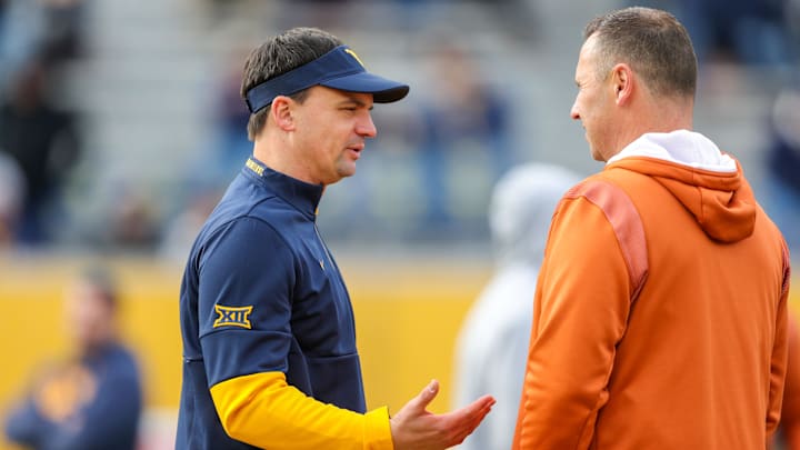 Nov 20, 2021; Morgantown, West Virginia, USA; West Virginia Mountaineers head coach Neal Brown talks with Texas Longhorns head coach Steve Sarkisian before the game at Mountaineer Field at Milan Puskar Stadium. Mandatory Credit: Ben Queen-Imagn Images