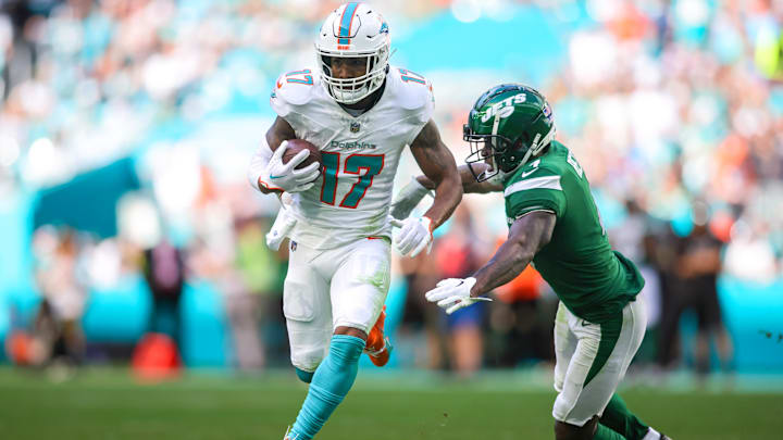 Dec 17, 2023; Miami Gardens, Florida, USA; Miami Dolphins wide receiver Jaylen Waddle (17) runs with the football past New York Jets cornerback D.J. Reed (4) during the second quarter at Hard Rock Stadium. Mandatory Credit: Sam Navarro-USA TODAY Sports