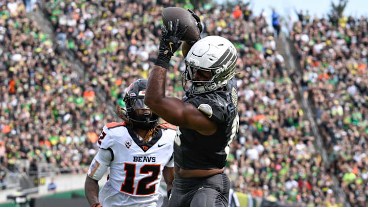 Sep 20, 2025; Eugene, Oregon, USA; Oregon Ducks tight end Kenyon Sadiq (18) makes a reception Oregon State Beavers defensive back Tyrice Ivy Jr. (12) of the game at Autzen Stadium. Sadiq scored a touchdown on the play. Mandatory Credit: Troy Wayrynen-Imagn Images