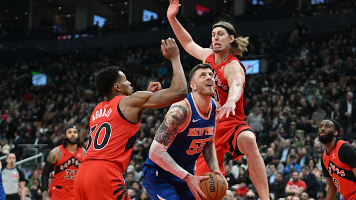 Mar 27, 2024; Toronto, Ontario, CAN; New York Knicks center Isaiah Hartenstein (55) drives against Toronto Raptors forward Kelly Olynyk (41) and guard Ochai Agbaji (30) in the first half at Scotiabank Arena. Mandatory Credit: Dan Hamilton-USA TODAY Sports