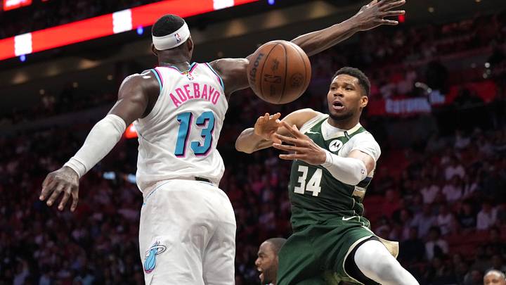 Apr 5, 2025; Miami, Florida, USA;  Milwaukee Bucks forward Giannis Antetokounmpo (34) passes the ball under the arm of Miami Heat center Bam Adebayo (13) during overtime at Kaseya Center. Mandatory Credit: Jim Rassol-Imagn Images