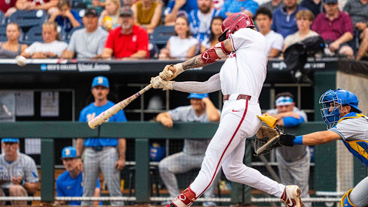 Jun 17, 2025; Omaha, Neb, USA; Arkansas Razorbacks shortstop Wehiwa Aloy (9) hits a two-run home run against the UCLA Bruins during the first inning at Charles Schwab Field. Mandatory Credit: Dylan Widger-Imagn Images