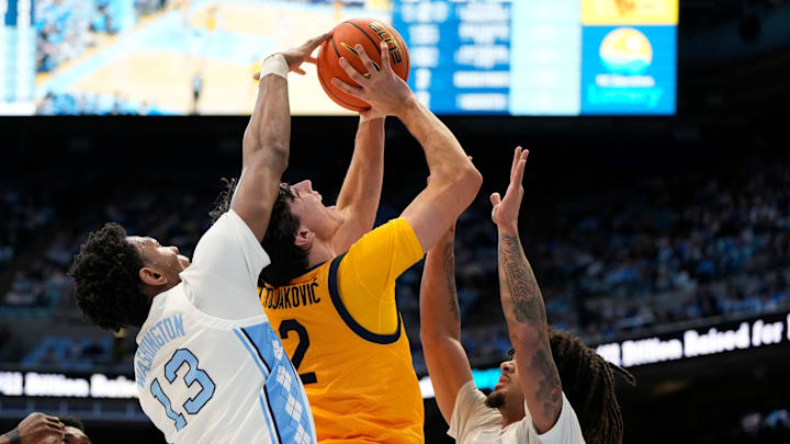 Jan 15, 2025; Chapel Hill, North Carolina, USA; North Carolina Tar Heels forward Jalen Washington (13) blocks the shot of California Golden Bears guard Andrej Stojakovic (2) as guard Elliot Cadeau (3) helps defend in the first half at Dean E. Smith Center. Mandatory Credit: Bob Donnan-Imagn Images