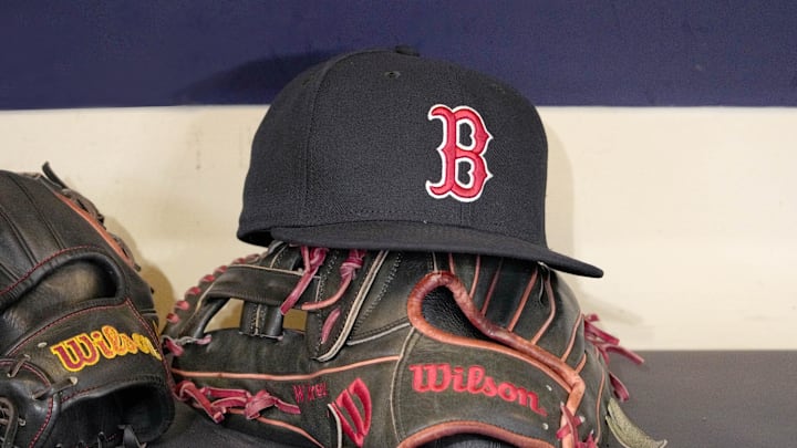 May 27, 2025; Milwaukee, Wisconsin, USA; A Boston Red Sox hat and glove sit in the dug out before a game against the Milwaukee Brewers at American Family Field. Mandatory Credit: Michael McLoone-Imagn Images