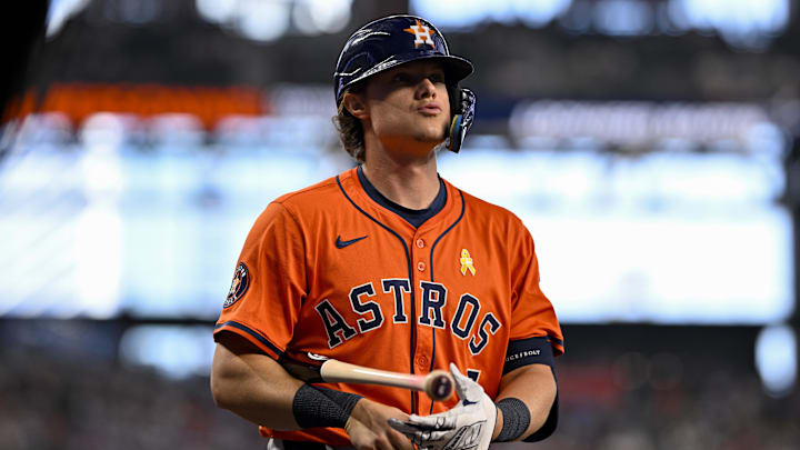 Houston Astros player Jake Meyers holds his bat under his arm in an orange jersey, dark blue helmet and gray pants.