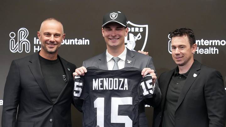 Apr 24, 2026; Henderson, NV, USA; Las Vegas Raiders quarterback Fernando Mendoza (center) poses with jersey at introductory press conference at Intermountain Health Performance Center flanked by general manager John Spytek (left) and head coach Klint Kubiak after being selected as the No. 1 pick in the 2026 NFL Draft. Mandatory Credit: Kirby Lee-Imagn Images