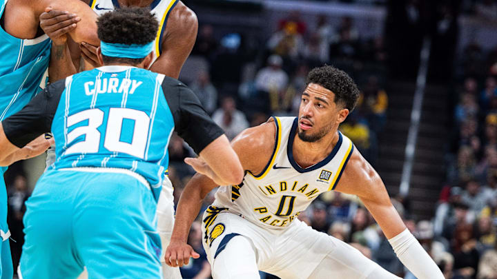 Oct 17, 2024; Indianapolis, Indiana, USA; Indiana Pacers guard Tyrese Haliburton (0) dribbles the ball while Charlotte Hornets guard Seth Curry (30) defends in the first half at Gainbridge Fieldhouse. Mandatory Credit: Trevor Ruszkowski-Imagn Images