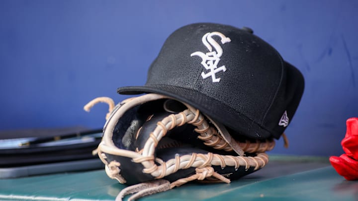 A detailed view of a Chicago White Sox hat and glove in the dugout against the Atlanta Braves in the first inning at Truist Park in 2023.