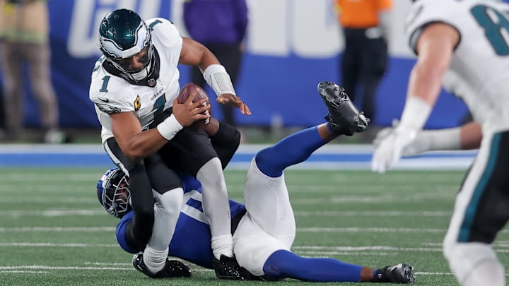 Oct 9, 2025; East Rutherford, New Jersey, USA; New York Giants linebacker Brian Burns (0) sacks Philadelphia Eagles quarterback Jalen Hurts (1) during the third quarter of the game at MetLife Stadium.