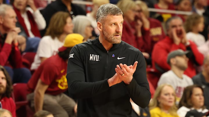 Feb 24, 2024; Ames, Iowa, USA; West Virginia Mountaineers head coach Josh Eilert watches his team play the Iowa State Cyclones in the first half at James H. Hilton Coliseum. Feb 24, 2024; Ames, Iowa, USA; West Virginia Mountaineers head coach Josh Eilert watches his team play the Iowa State Cyclones in the first half at James H. Hilton Coliseum.