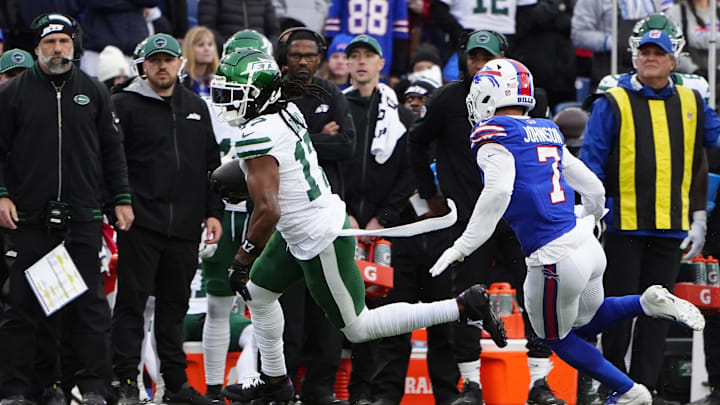 Dec 29, 2024; Orchard Park, New York, USA; New York Jets wide receiver Davante Adams (17) runs with the ball against Buffalo Bills cornerback Taron Johnson (7) during the second half at Highmark Stadium. Mandatory Credit: Gregory Fisher-Imagn Images