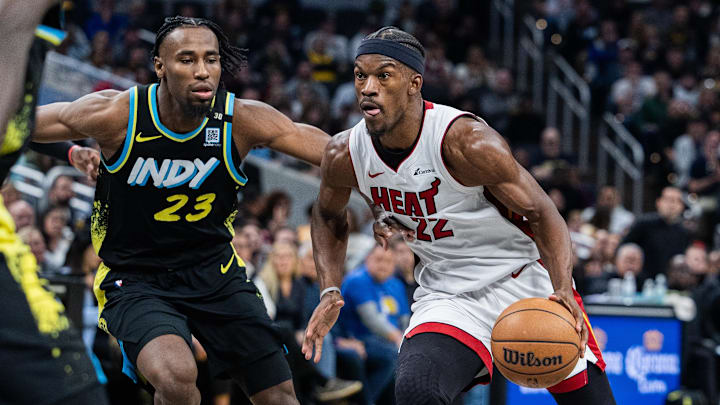 Apr 7, 2024; Indianapolis, Indiana, USA; Miami Heat forward Jimmy Butler (22) dribbles the ball while Indiana Pacers forward Aaron Nesmith (23) defends in the second half at Gainbridge Fieldhouse. Mandatory Credit: Trevor Ruszkowski-Imagn Images