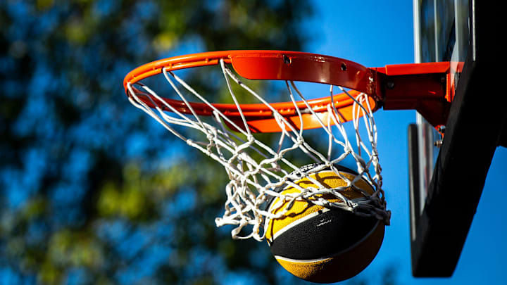 An Iowa basketball falls through the basket during the Hawkeye Hoops from Downtown event with the men's and women's basketball programs, Friday, Sept. 30, 2022, on Iowa Avenue in Iowa City, Iowa.

220930 Hoops Downtown 013 Jpg