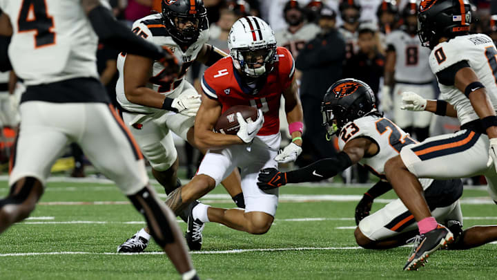 Oct 28, 2023; Tucson, Arizona, USA; Arizona Wildcats wide receiver Tetairoa McMillan #4 runs for a first down against Oregon State Beavers defensive back Jermod McCoy #23 during the first half at Arizona Stadium. Mandatory Credit: Zachary BonDurant-Imagn Images