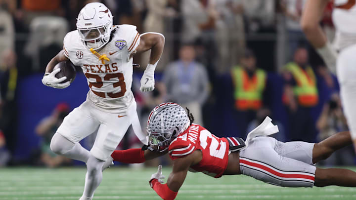Jan 10, 2025; Arlington, Texas, USA; Texas Longhorns running back Jaydon Blue (23) is tackled by Ohio State Buckeyes cornerback Jermaine Mathews Jr. (24) during the third quarter of the College Football Playoff semifinal in the Cotton Bowl at AT&T Stadium. 