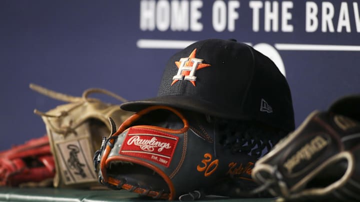 A Houston Astros cap resting on top of a baseball glov