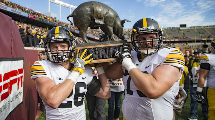 Oct 8, 2016; Minneapolis, MN, USA; Iowa Hawkeyes running back Marcel Joly (26) and Iowa Hawkeyes offensive lineman Ike Boettger (75) hold up the Floyd of Rosedale Trophy after defeating the Minnesota Golden Gophers  at TCF Bank Stadium. The Hawkeyes won 14-7. Mandatory Credit: Jesse Johnson-Imagn Images