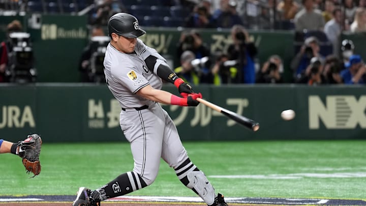Mar 16, 2025; Bunkyo, Tokyo, Japan; Yomiuri Giants first baseman Kazuma Okamoto (25) hits a single against the Chicago Cubs during the second inning at Tokyo Dome. Mandatory Credit: Darren Yamashita-Imagn Images