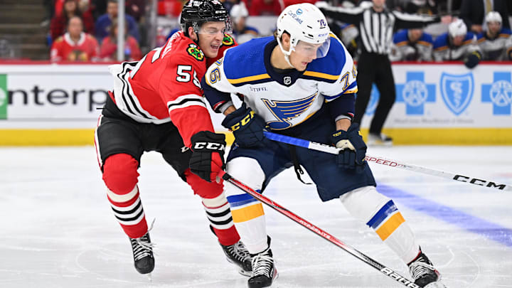 Sep 28, 2023; Chicago, Illinois, USA; Chicago Blackhawks defenseman Kevin Korchinski (55) defends against St. Louis Blues forward Zachary Bolduc (76) in the second period at United Center. Mandatory Credit: Jamie Sabau-USA TODAY Sports