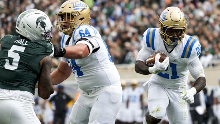 Oct 11, 2025; East Lansing, Michigan, USA; UCLA Bruins running back Jaivian Thomas (21) runs the ball against the Michigan State defense in the second quarter at Spartan Stadium. Mandatory Credit: Brendan Mullin-Imagn Images Oct 11, 2025; East Lansing, Michigan, USA; UCLA Bruins running back Jaivian Thomas (21) runs the ball against the Michigan State defense in the second quarter at Spartan Stadium. Mandatory Credit: Brendan Mullin-Imagn Images