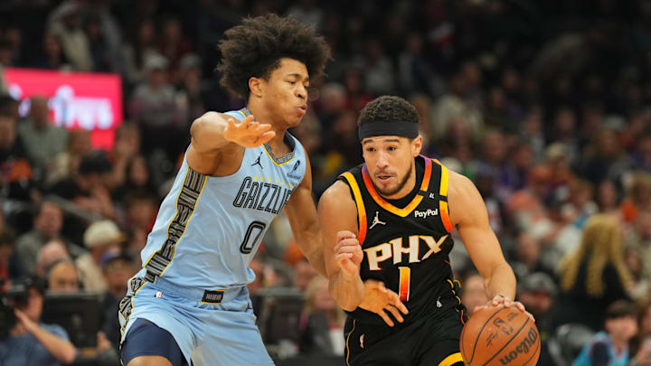 Feb 11, 2025; Phoenix, Arizona, USA; Memphis Grizzlies forward Jaylen Wells (0) guards Phoenix Suns guard Devin Booker (1) during the first half at Footprint Center. Mandatory Credit: Joe Camporeale-Imagn Images