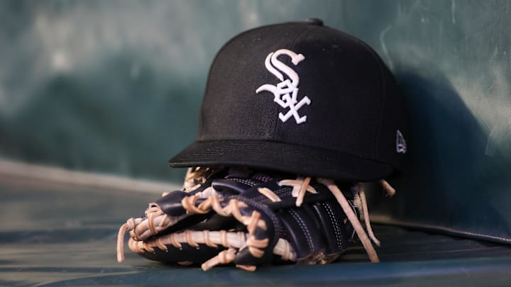 A detailed view of a Chicago White Sox hat and glove in the dugout against the Atlanta Braves in the fourth inning at Truist Park. Mandatory Credit: Brett Davis-Imagn Images