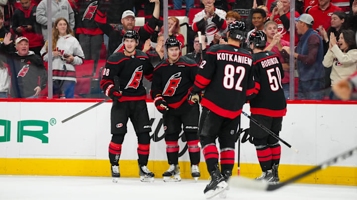 Nov 3, 2024; Raleigh, North Carolina, USA;  Carolina Hurricanes defenseman Dmitry Orlov (7) celebrates his goal with center Martin Necas (88) left wing Eric Robinson (50) and center Jesperi Kotkaniemi (82) against the Washington Capitals during the first period at Lenovo Center. Mandatory Credit: James Guillory-Imagn Images