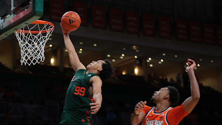 Feb 11, 2025; Coral Gables, Florida, USA; Miami Hurricanes guard Divine Ugochukwu (99) drives to the basket past Syracuse Orange guard J.J. Starling (2) during the second half at Watsco Center. Mandatory Credit: Sam Navarro-Imagn Images