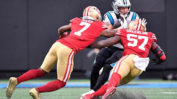 San Francisco 49ers cornerback Charvarius Ward (7) and linebacker Dre Greenlaw (57) tackle Carolina Panthers running back Christian McCaffrey (23)