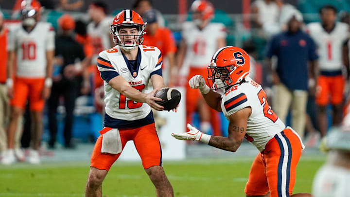 Nov 8, 2025; Miami Gardens, Florida, USA; Syracuse Orange quarterback Joseph Filardi (13) hands off to running back Jaden Hart (22) against the Miami Hurricanes during the fourth quarter at Hard Rock Stadium. Mandatory Credit: Jeff Romance-Imagn Images Nov 8, 2025; Miami Gardens, Florida, USA; Syracuse Orange quarterback Joseph Filardi (13) hands off to running back Jaden Hart (22) against the Miami Hurricanes during the fourth quarter at Hard Rock Stadium. Mandatory Credit: Jeff Romance-Imagn Images