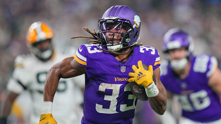Dec 29, 2024; Minneapolis, Minnesota, USA; Minnesota Vikings running back Aaron Jones (33) runs with the ball against Green Bay Packers in the third quarter at U.S. Bank Stadium. Mandatory Credit: Brad Rempel-Imagn Images