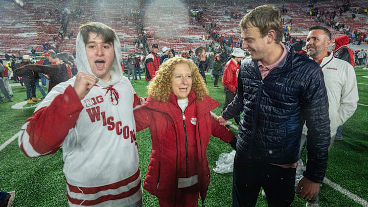 UW-Madison Chancellor Jennifer Mnookin poses with Wisconsin Badgers football fans who stormed the field after their team beat No. 23 Washington Saturday, November 8, 2025 at Camp Randall Stadium in Madison, Wisconsin. Wisconsin beat Washington 13-10.