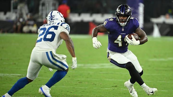 Aug 7, 2025; Baltimore, Maryland, USA; Baltimore Ravens linebacker Jay Higgins IV (49) runs back an interception in front of Indianapolis Colts running back Khalil Herbert (26) during the fourth quarter at M&T Bank Stadium. Mandatory Credit: Rafael Suanes-Imagn Images