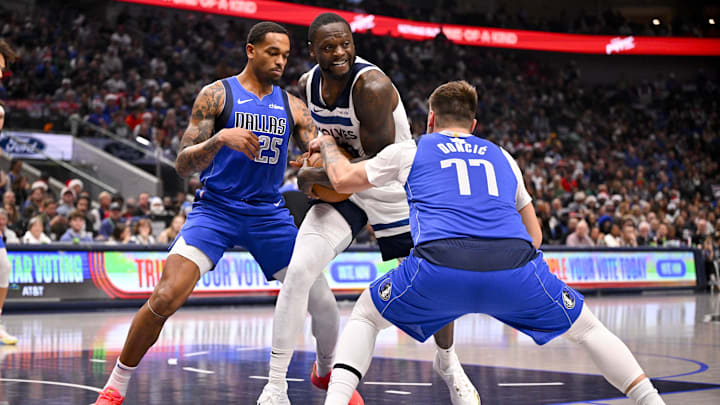 Minnesota Timberwolves forward Julius Randle looks to move the ball past Dallas Mavericks forward P.J. Washington and guard Luka Doncic (77) during the first quarter at the American Airlines Center in Dallas on Dec. 25, 2024.