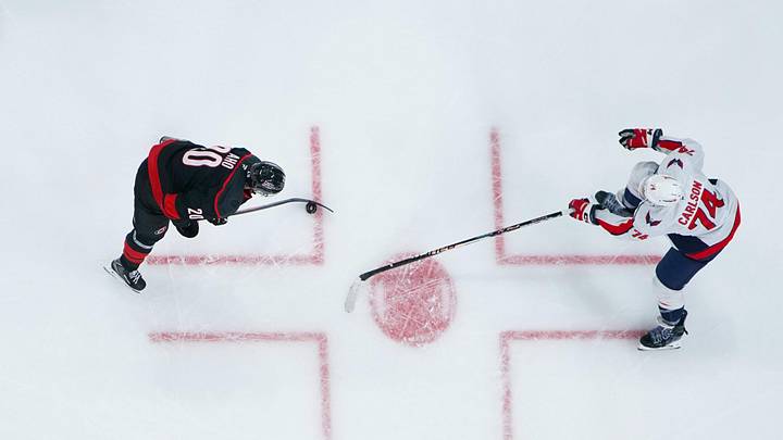Nov 11, 2025; Raleigh, North Carolina, USA;  Carolina Hurricanes center Sebastian Aho (20) skates with the puck against Washington Capitals defenseman John Carlson (74) during the second period at Lenovo Center. Mandatory Credit: James Guillory-Imagn Images