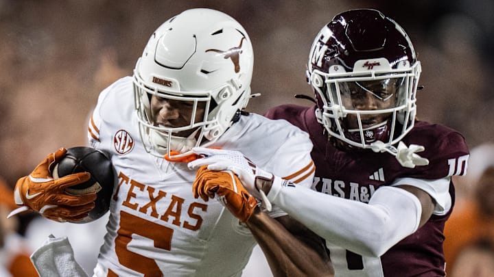 Nov 30, 2024; College Station, Texas, USA; Texas Longhorns wide receiver Ryan Wingo (5) carries the ball against Texas A&M Aggies defensive back Dezz Ricks (10) in the second quarter of the Lone Star Showdown game at Kyle Field. Mandatory Credit: Sara Diggins/USA TODAY Network via Imagn Images