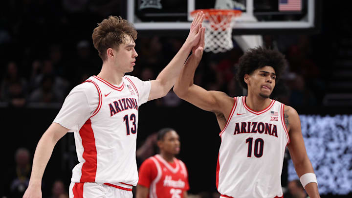 Mar 14, 2026; Kansas City, MO, USA; Arizona Wildcats center Motiejus Krivas (13) and forward Koa Peat (10) high-five during the second half against the Houston Cougars during the men's Big 12 Conference Tournament Championship at T-Mobile Center. Mandatory Credit: William Purnell-Imagn Images