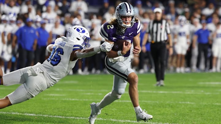 Sep 21, 2024; Provo, Utah, USA; Kansas State Wildcats quarterback Avery Johnson (2) breaks a tackle by Brigham Young Cougars linebacker Isaiah Glasker (16) during the third quarter at LaVell Edwards Stadium. Mandatory Credit: Rob Gray-Imagn Images