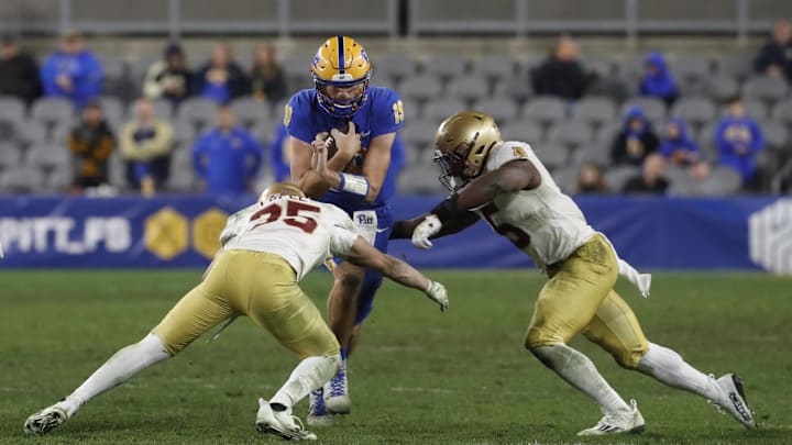 Nov 16, 2023; Pittsburgh, Pennsylvania, USA; Pittsburgh Panthers quarterback Nate Yarnell (19) runs the ball as Boston College Eagles defensive back John Pupel (35) and linebacker Kam Arnold (5) defend during the fourth quarter at Acrisure Stadium. Pittsburgh won 24-16. Mandatory Credit: Charles LeClaire-Imagn Images